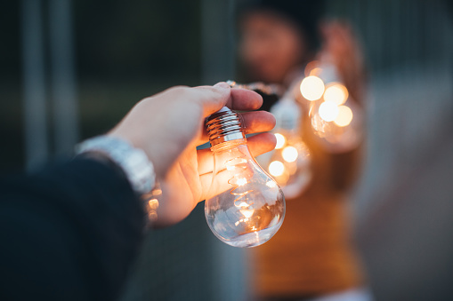 Couple standing on the bridge and holding light bulbs