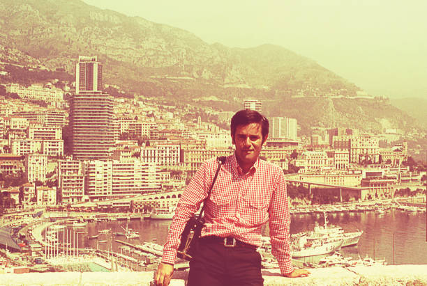 Vintage visit to Cannes Vintage image from the seventies featuring a man standing against a view of the city of Cannes behind him. vintage people stock pictures, royalty-free photos & images