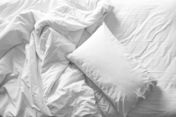 istock Messy bed. White pillow with blanket on bed unmade. Top view. Black and white theme. 861667984