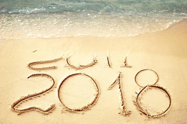 New Year 2018 replace 2017 on sea beach summer, New Year 2017 is coming concept. Closeup.