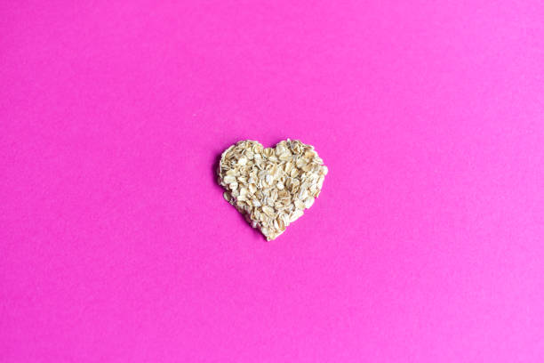 haferflocken in herzform - oatmeal oat heart shape rolled oats stock-fotos und bilder