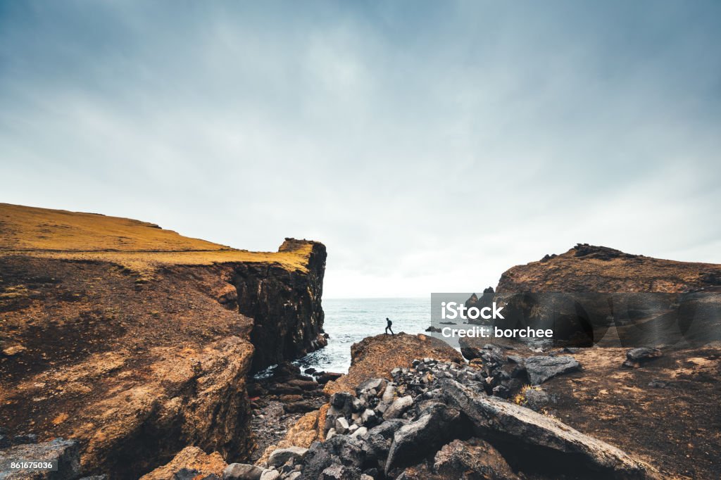 Hiking On Valahnukur Cliffs In Iceland Man hiking on Valahnukur cliffs in Iceland. Landscape - Scenery Stock Photo
