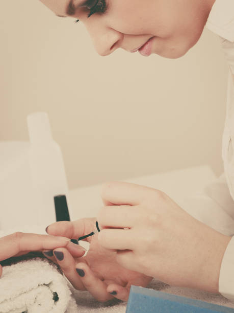 istock Woman in beauty salon getting manicure done. 861678618