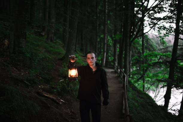 istock Man walking   in the forest with gas lantern 861678640