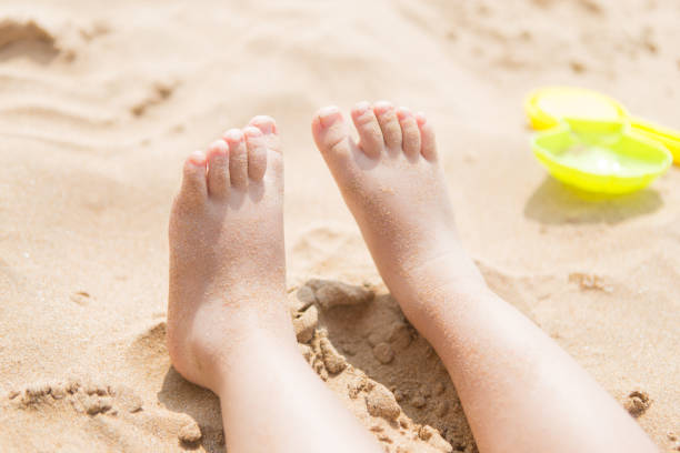 Child's foot is close to the beach Child's foot is close to the beach unknown gender stock pictures, royalty-free photos & images