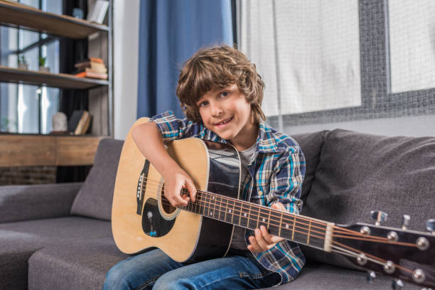 istock child playing acoustic guitar 861685542