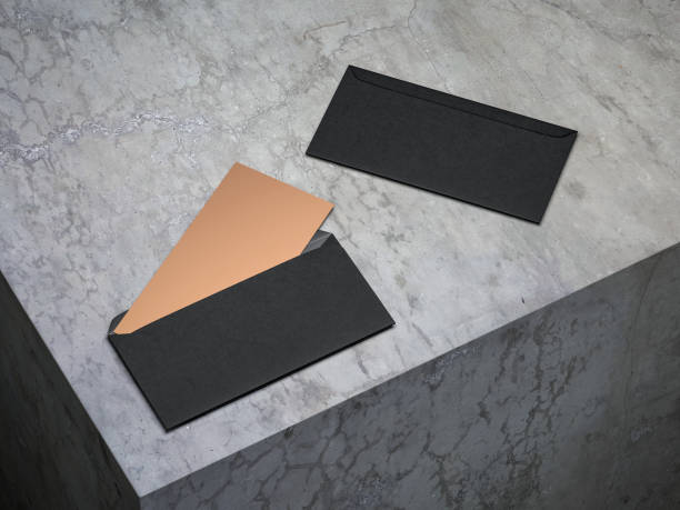 Golden invitation mockup in open black envelope on concrete floor