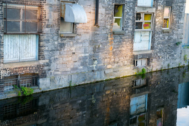 Old building in Dublin on canal in process of redevelopment in to city apartmentscloseup  reflected in canal below.