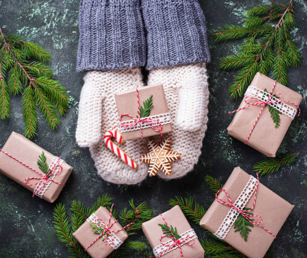 istock Hands in mittens holding Christmas gift box and gingerbread cook 861701760