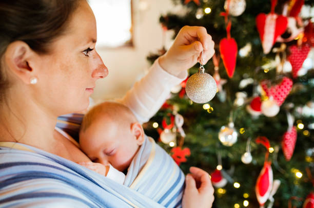 istock Young woman with a baby decorating Christmas tree. 861703204