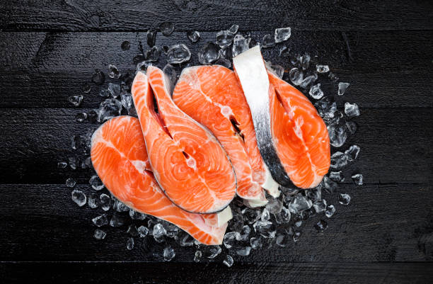 istock Salmon steaks on ice on black wooden table top view 861705358