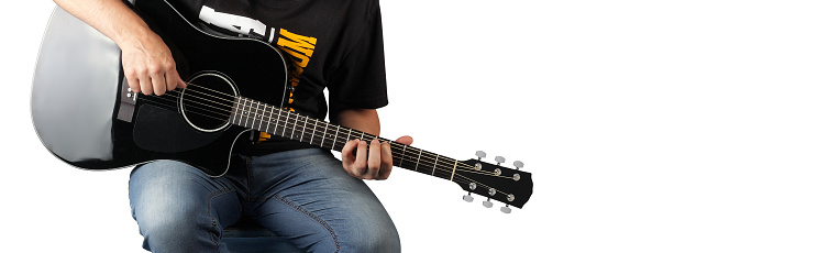 Music - fragment man play a black acoustic guitar on a white background.