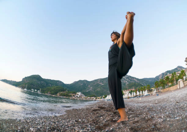 istock Practicing yoga and meditation in summer on beach 861725482