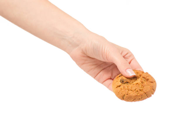 istock Female hand holding cookies with raisins isolated 861728412