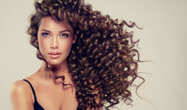 jóvenes, marrón pelo hermosa modelo con el pelo largo, ondulado, bien cuidado. tensos, resorte-como rizos en el pelo. - frizzy human hair women curly hair fotografías e imágenes de stock