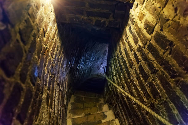 Downstairs in ancient stone tower tunnel Downstairs in ancient stone dungeon tower tunnel in darkness ancient arch architecture brick stock pictures, royalty-free photos & images