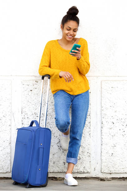 istock Cheerful woman with suitcase using mobile phone 861761632
