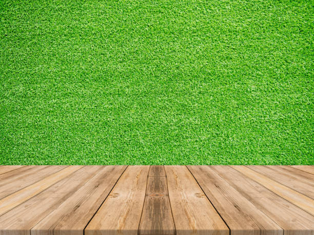 istock Wooden board empty table top on of grass wall background. Perspective brown wood table over green pattern wall background - can be used mock up for montage products display or design key visual layout 861762126