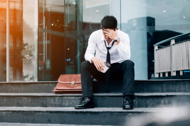 paro cansado o estresado hombre de negocios sentado en el pasillo después del trabajo concepto de empresario stressed - unemployment fotografías e imágenes de stock