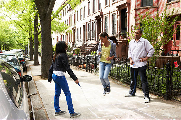 vater und tochter spielen springen seil - brooklyn brownstone new york city row house stock-fotos und bilder