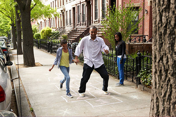 vater & töchter spielen hop-scotch - brooklyn brownstone new york city row house stock-fotos und bilder