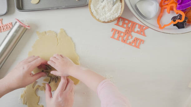istock Mother and daughter maaking Halloween sugar cookies. 861783178