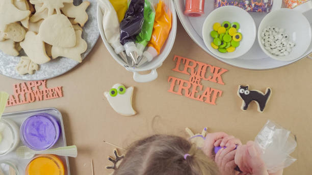istock Mother and daughter decorating Halloween sugar cookies 861783214