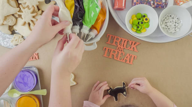 istock Mother and daughter decorating Halloween sugar cookies 861784880