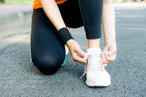 istock Young Asian female runner sitting down putting shoe lace together 861798310