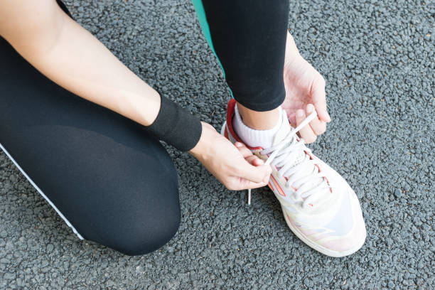 istock Young Asian female runner sitting down putting shoe lace together 861798520