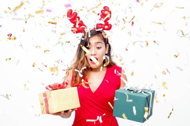istock Surprised emotional woman choosing gift under confetti 861804936