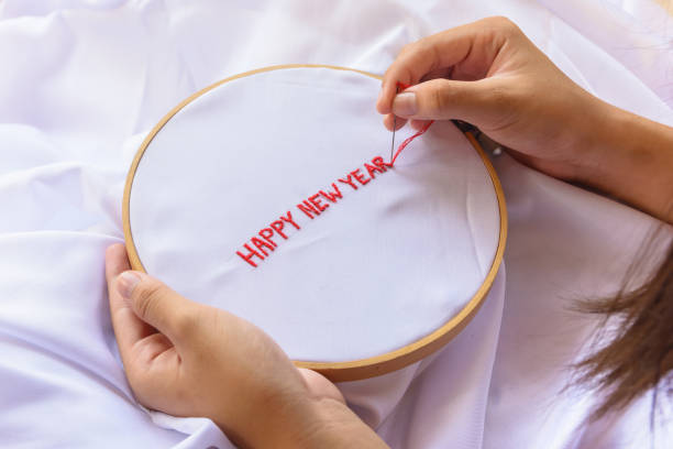 istock Handmade a text happy new year with sewing needle on white garment background. Concept and idea happy new year background 861805130