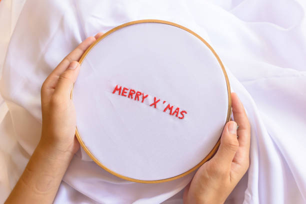istock Handmade a text Merry Christmas with sewing needle on white garment background. Concept and idea Merry Christmas background 861805196