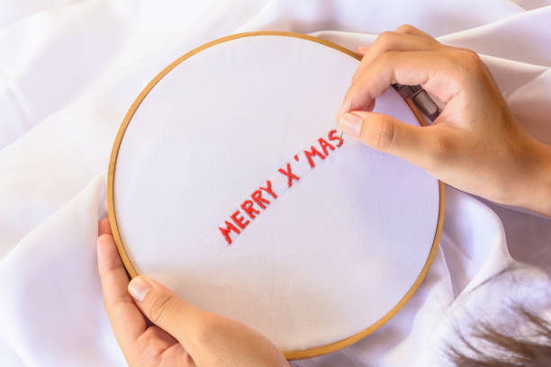 istock Handmade a text Merry Christmas with sewing needle on white garment background. Concept and idea Merry Christmas background 861805230