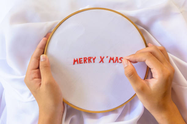 istock Handmade a text Merry Christmas with sewing needle on white garment background. Concept and idea Merry Christmas background 861805256