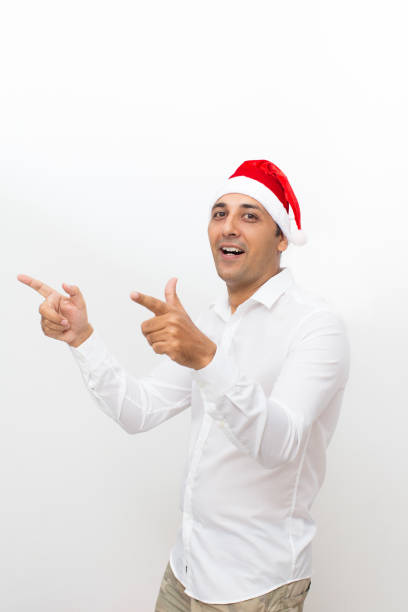 istock Happy Man Wearing Santa Hat and Pointing Away 861807840