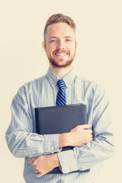 portrait de gestionnaire heureux holding etui cuir - book holding necktie businessman photos et images de collection