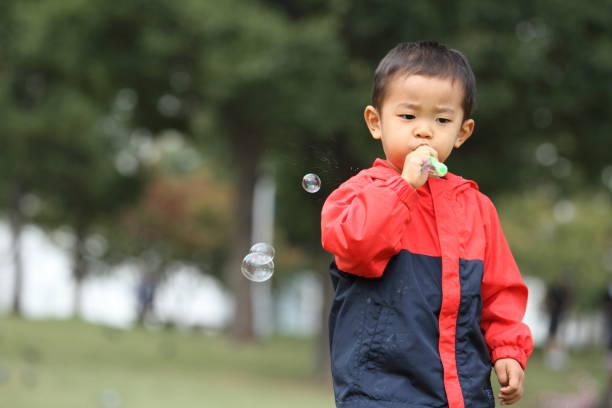 istock Japanese boy playing with bubble (3 years old) on the grass 861814094