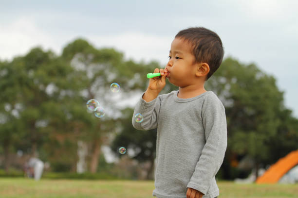 istock Japanese boy playing with bubble (3 years old) on the grass 861814108