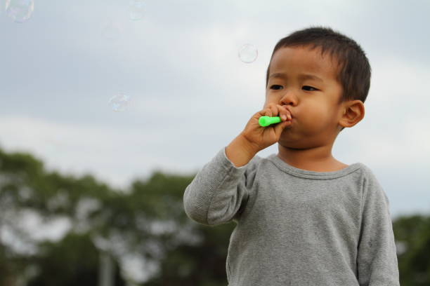 istock Japanese boy playing with bubble (3 years old) on the grass 861814140