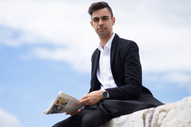 istock Serious ambitious young man holding newspaper 861814486