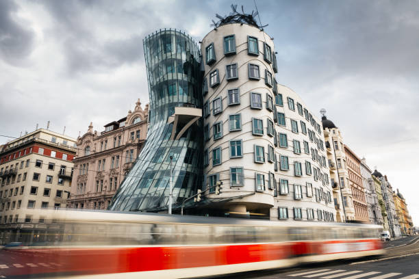 Dancing House In Prague Prague, Czech Republic - February 05, 2013: Moving red tram in front of Dancing house in Prague. The building was designed by the architect Vlado Milunić in cooperation with Frank Gehry. It was designed in 1992 and completed in 1996. dancing house prague stock pictures, royalty-free photos & images