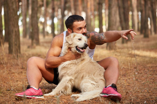 istock Handsome young man with a labrador outdoors in the forest. 861831424