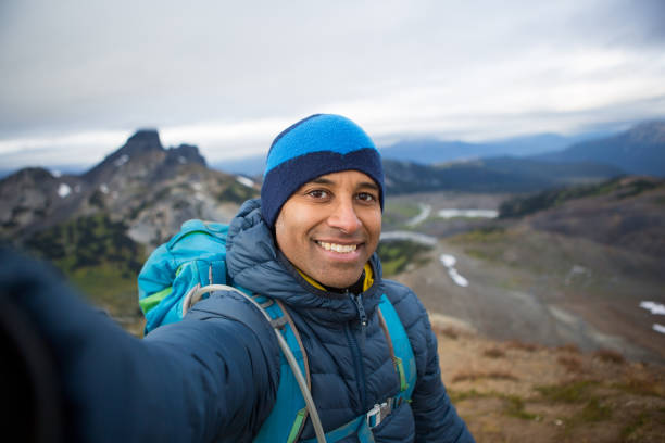 An African Male stands proud on top of the mountain and snaps a selfie of himself - Personal Perspective