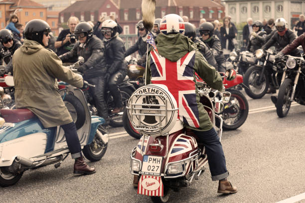 mods wearing uk flag and rockers wearing leather clothes driving retro vespa scooters and mc at the mods vs rockers event - vespa scooter imagens e fotografias de stock