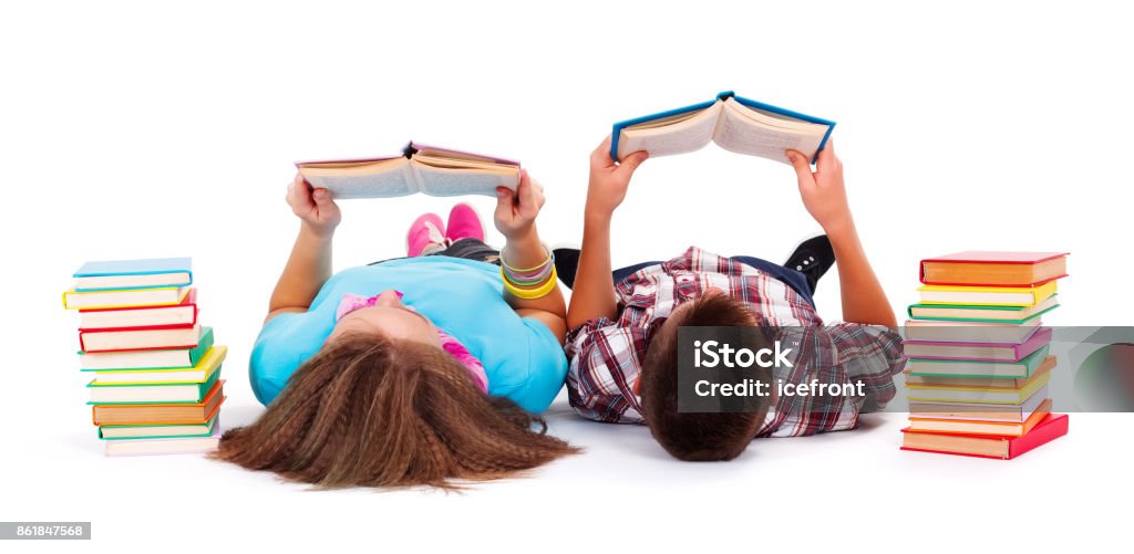 Teens reading books Teens with books next to them laying on the floor and reading Child Stock Photo