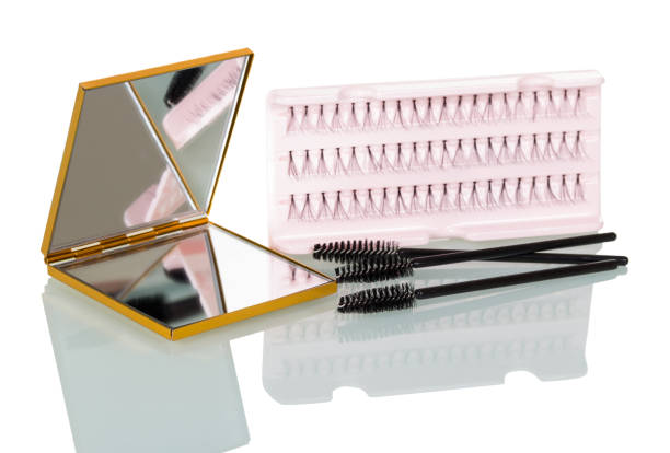 A set of false eyelashes bunches, brush for applying mascara and mirror isolated on white. A set of false eyelashes bunches, a brush for applying mascara and a mirror isolated on white background. clump eyelashes stock pictures, royalty-free photos & images