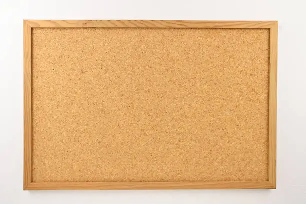 Cork board with a wooden frame against a white background