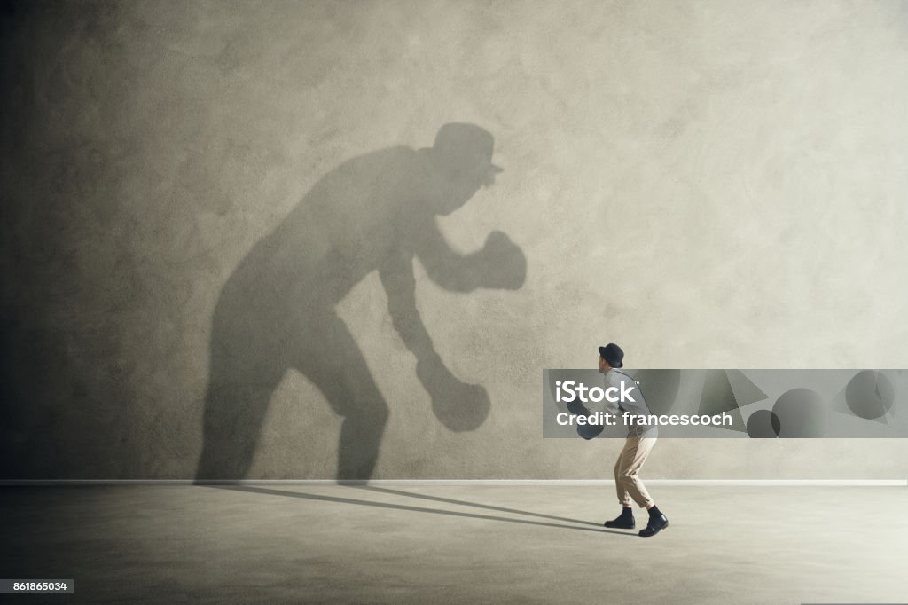 man fighting with his shadow, facing fears Boxing - Sport Stock Photo