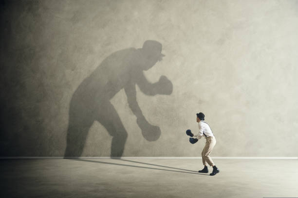 man fighting with his shadow, facing fears man fighting with his shadow, facing fears rivalry stock pictures, royalty-free photos & images